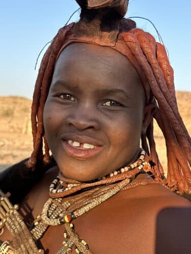 up close himba woman smiling Visiting a himba village from Hoanib Valley Camp Kaokoland with Natural Selection Travel Danica Wilson 2023